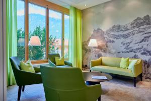 un soggiorno con divano, sedie e tavolo di Ferien- und Familienhotel Alpina Adelboden ad Adelboden