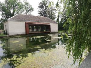 un edificio con un laghetto di fronte di Maison accueillante a Gondrecourt-le-Château