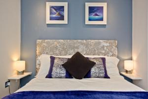 a bedroom with a large bed with two lamps at Blue Bay, Marazion in Perranuthnoe