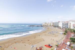 a view of a beach with people and buildings at Estudio en primera línea Las Canteras in Las Palmas de Gran Canaria
