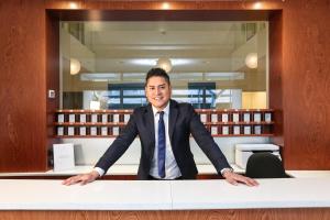 a man in a suit and tie sitting at a desk at Wally Residence in Rimini