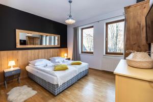 um quarto com uma cama grande e almofadas amarelas em TatryTOP Radowid basen sauna em Zakopane