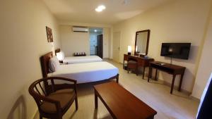 a hotel room with a bed and a desk and a television at Fanar Hotel in Ain Sokhna