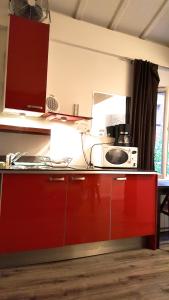 パリにあるスタジオ ル レセペードのキッチン(赤いカウンター、電子レンジ付)