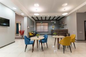 a waiting room with two tables and chairs at Bastau Hotel in Almaty