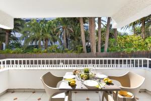 a table and chairs on a balcony with palm trees at Apartment Tindaya MT Maspalomas by VillaGranCanaria in Maspalomas