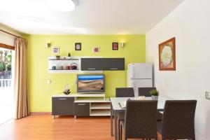 a dining room with a table and a tv on a wall at Apartment Tindaya MT Maspalomas by VillaGranCanaria in Maspalomas