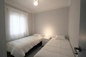 2 camas en una habitación pequeña con ventana en 036 - Sierramar 001 - comfortHOLIDAYS, en Santa Pola