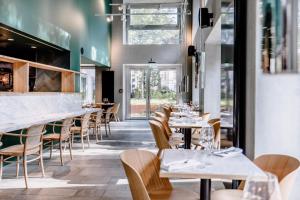 un restaurante con mesas y sillas y un bar en THE FLAG West M., en Frankfurt