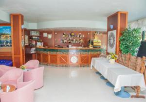 a restaurant with a bar with pink chairs at Hotel Costazzurra in Grottammare
