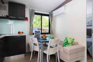 a small kitchen and dining room with a table and chairs at Fornella Camping & Wellness family resort in San Felice del Benaco