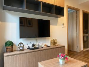 a living room with a flat screen tv on a wall at La HABANA Condo 135/500 in Hua Hin