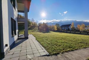 uma varanda de uma casa com um campo de relva em EdanApartments em Tohanu Nou