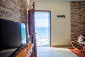 sala de estar con TV grande y vistas al océano en Casa Lucia, en Playa Quemada