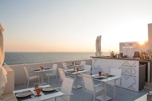 a restaurant with a view of the ocean with tables and chairs at Dimora Talenti in Polignano a Mare