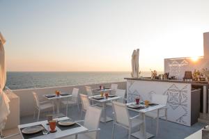 un ristorante con vista sull'oceano, tavoli e sedie di Dimora Talenti a Polignano a Mare