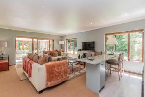 ein Wohnzimmer mit einem Sofa und einem Tisch in der Unterkunft Fernwood Manor Boutique Guest House in Kapstadt