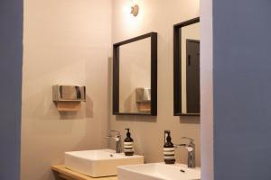 a bathroom with two sinks and two mirrors at hostel mog in Ueda