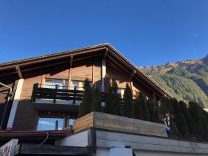 a house with a balcony on the side of it at Central Wengen Wonderland: Mezzanine Studio for 4 in Wengen