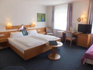 Postel nebo postele na pokoji v ubytování TIPTOP Hotel Garni Pfauen