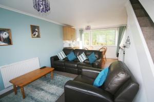 a living room with a couch and a table at Freshwater Bay Holiday Cottages in Pembroke