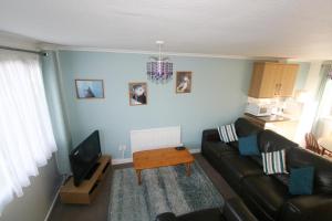 a living room with a couch and a table at Freshwater Bay Holiday Cottages in Pembroke