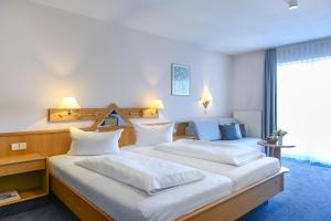 Postel nebo postele na pokoji v ubytování TIPTOP Hotel Garni Pfauen