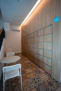 um quarto com uma mesa e duas cadeiras e uma parede em Bobopod Slamet Riyadi, Solo em Solo