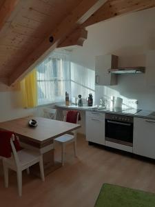 a kitchen with a wooden table and a dining room at Ferienwohnung Christine in Altaussee