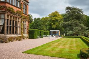 a courtyard of a house with a lawn and chairs at Hoar Cross Hall in Newborough