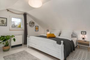 a bedroom with a white bed with a yellow pillow at FOREST & MOUNTAIN - 2min Bikepark, SNES, SSC, Bikegarage, Terrace in Winterberg