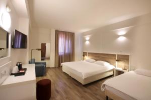 a hotel room with two beds and a television at Centrum Hotel - City Center in Nicosia
