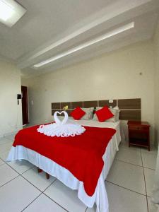 ein Schlafzimmer mit einem roten und weißen Bett mit einem Schwan darauf in der Unterkunft Hotel Borari in Alter do Chao