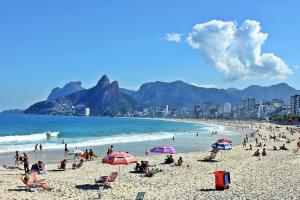 a group of people on a beach with the ocean at Rio Spot Ipanema C011 in Rio de Janeiro