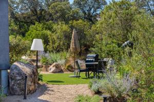 um jardim com um piano no meio de um quintal em Les Villas de Palombaggia em Porto-Vecchio