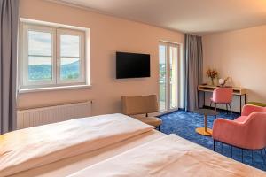 Struppen-SiedlungにあるHotel Bei Gretel, Wellness & Ayurvedaのベッドとデスクが備わるホテルルームです。