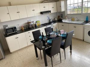 a kitchen with a black table and chairs in a kitchen at Larnaca Comfort Rooms With Smart TV & Netflix in Larnaca