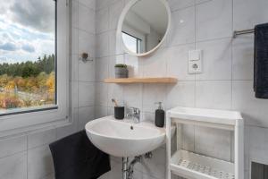 a white bathroom with a sink and a mirror at FOREST & MOUNTAIN - 2min Bikepark, SNES, SSC, Bikegarage, Terrace in Winterberg