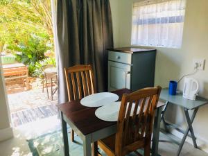 Una mesa de comedor y sillas con una mesa y una ventana. en Baylight Accomodation Room 2, en Mossel Bay