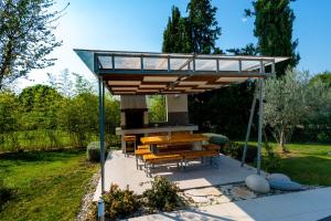 a pavilion with a table and benches in a garden at Casa Bamboo in Banjole