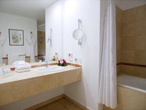 a bathroom with a sink and a bath tub at Holiday Inn Resort le Touquet, an IHG Hotel in Le Touquet-Paris-Plage
