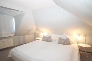 ein weißes Bett mit zwei Kissen in einem Zimmer in der Unterkunft Residenz Ostseewind - Wohnung 12 / 9571 in Kühlungsborn