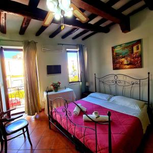 a bedroom with a large bed with a red blanket at Due Passi Dal Centro in Marsala