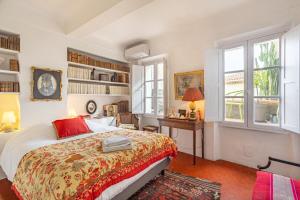 a bedroom with a bed and a desk and windows at La Maison du Prince in Grimaud