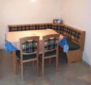 einem Holztisch mit 2 Stühlen und einem Tisch mit in der Unterkunft Ferienwohnung Ferstl in Riedenburg + 8 Fotos