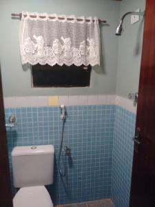 a bathroom with a shower with a toilet and a window at Casa acolhedora. in Maresias +15 photos