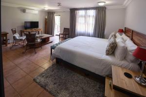a bedroom with a large bed and a living room at 250onIndus in Pretoria +15 photos