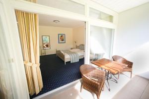 Zimmer mit einem Schlafzimmer mit einem Tisch und einem Bett in der Unterkunft Hotel Aselager Mühle in Herzlake