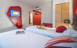 two beds in a room with red and white at Promotel in Carros