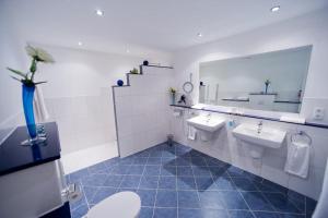 a bathroom with two sinks and a mirror at Hotel Aselager Mühle in Herzlake